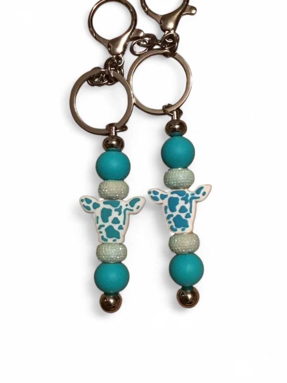 2 Teal and white beaded cow keychains